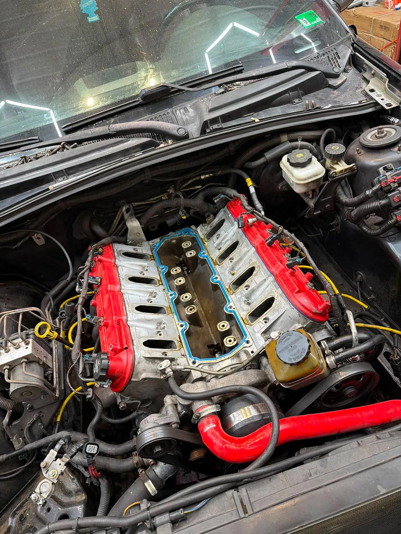 LS Engine Build Close-up — Detailed view of an LS engine block with red valve covers during assembly.